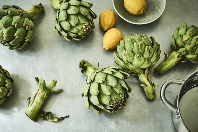Alcachofas y limones verdes - foto de stock