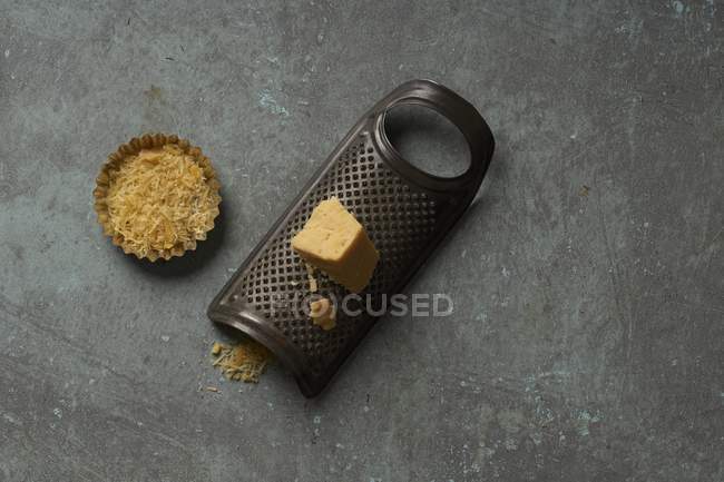 Chunk of cheese on grater — Stock Photo