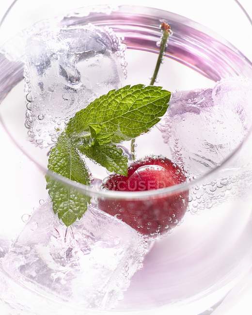 Vaso de agua con cereza - foto de stock