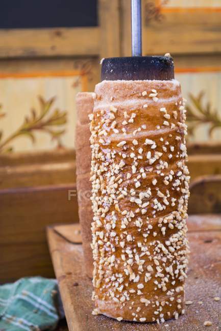 Closeup view of Kurtoskalacs Hungarian dessert with nuts — Stock Photo