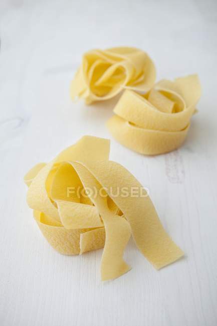 Nidos secos de pasta sin cocer de Parpadelle - foto de stock