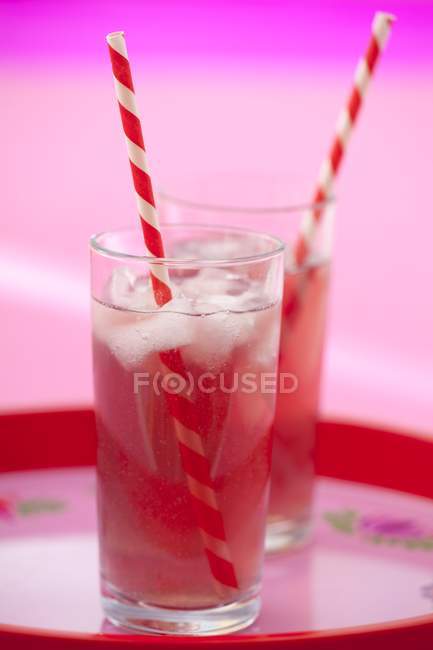 Vista de cerca de refrescantes bebidas de frambuesa en vasos - foto de stock