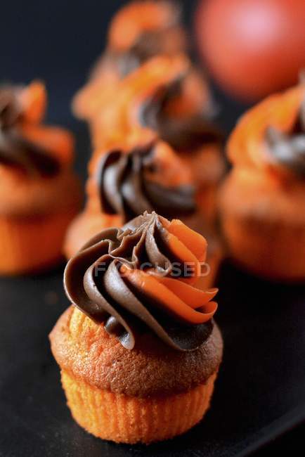 Muffins with chocolate and orange frosting — Stock Photo