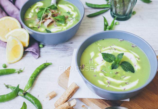 Pea soup with mint leaves in bowls — Stock Photo