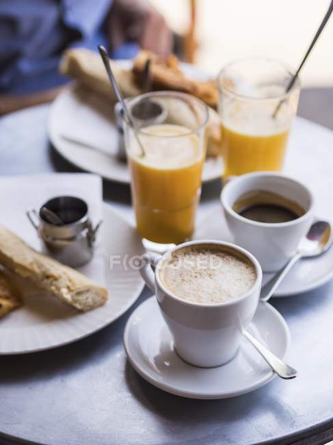 Vista elevada del desayuno francés servido en la mesa de café - foto de stock