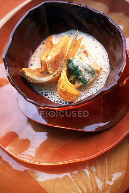 Closeup view of peach soup with saffron and freshwater fish — Stock Photo