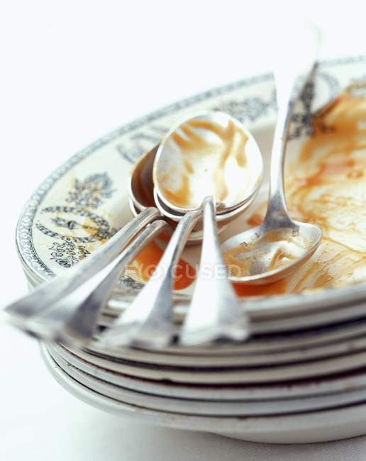 Closeup view of dirty piled plates and spoons — Stock Photo