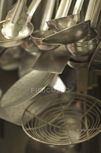 Vista de cerca de los utensilios de cocina colgantes - foto de stock