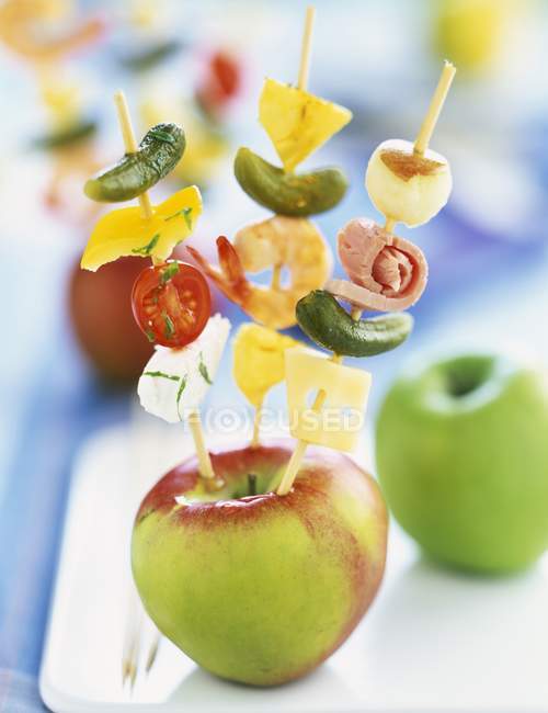 Vue rapprochée de brochettes d'apéritif piquées dans une pomme — Photo de stock