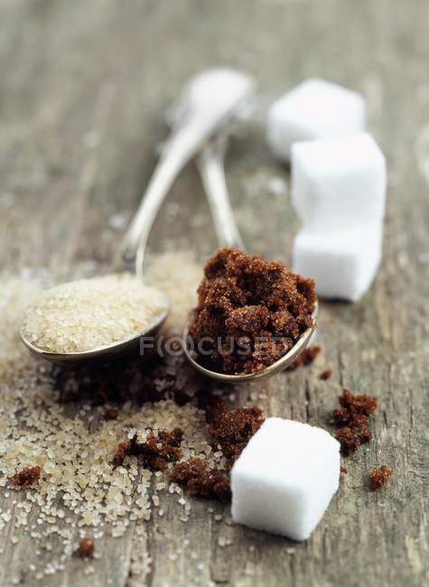 Azúcares surtidos en cucharas - foto de stock