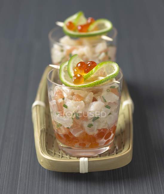 Closeup view of bream tartare with lime slices in glasses — Stock Photo