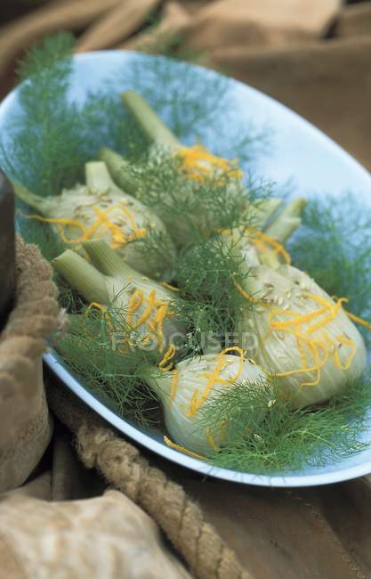 Fennel with orange and anise seeds on blue plate — Stock Photo
