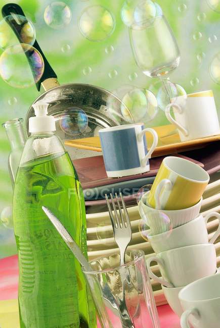 Closeup view of piled crockery with washing gel and bubbles — Stock Photo