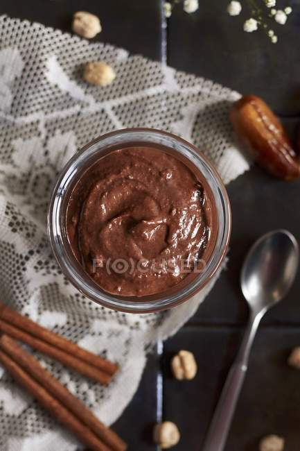 Top view of vegan chickpea sweet paste in jar with spices and chickpeas around — Stock Photo