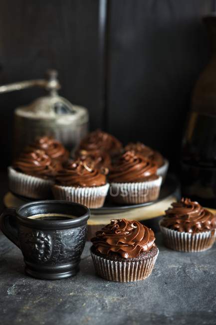 Vue rapprochée des gâteaux de tasse de chocolat et boisson — Photo de stock