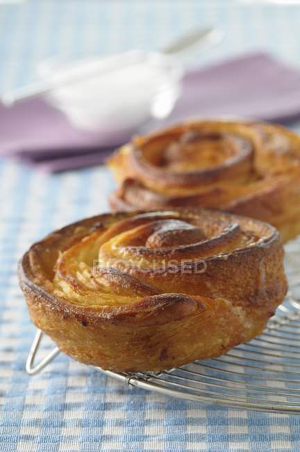 Small Kouign Amanns on wire rack over tablecloth — Stock Photo