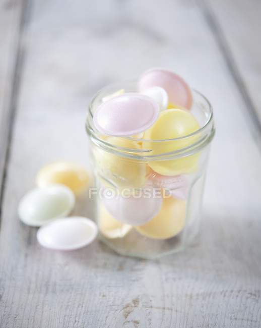 Acidulated capsules in glass jar over grey wooden surface — Stock Photo