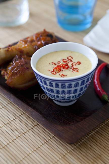 Thai peanut dip sauce in small blue bowl over tray — Stock Photo