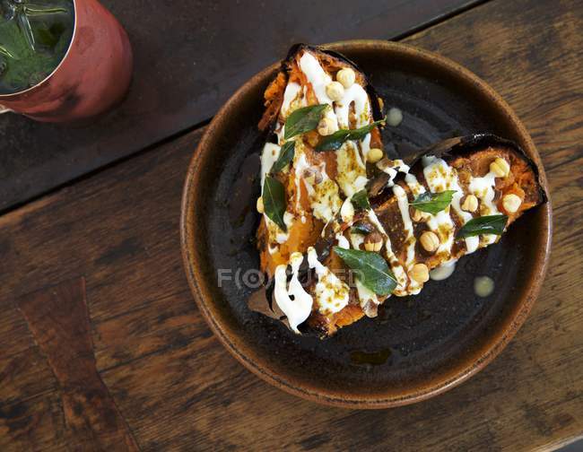 Patata dolce speziata indiana in ciotola marrone su superficie di legno — Foto stock