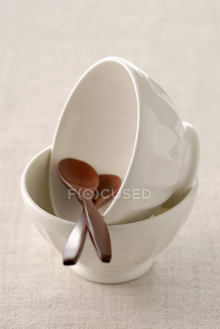 Closeup view of white bowls and wooden spoons — Stock Photo