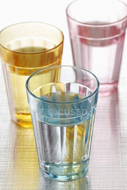 Vue rapprochée de verres d'eau colorés — Photo de stock