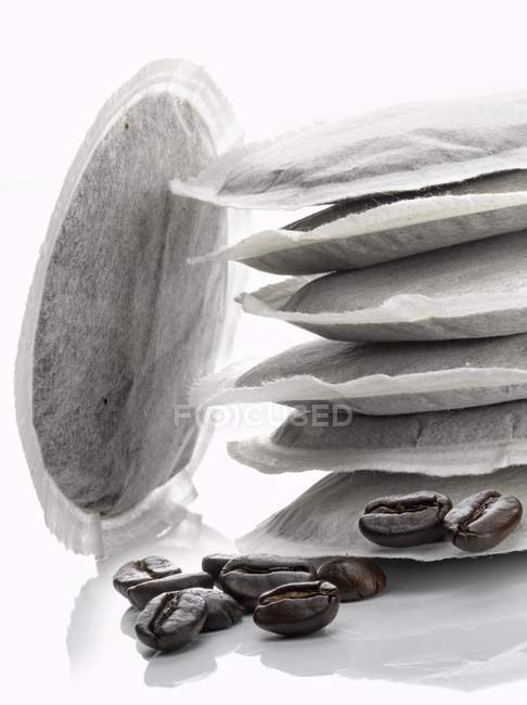 Closeup view of round coffee bags and beans — Stock Photo
