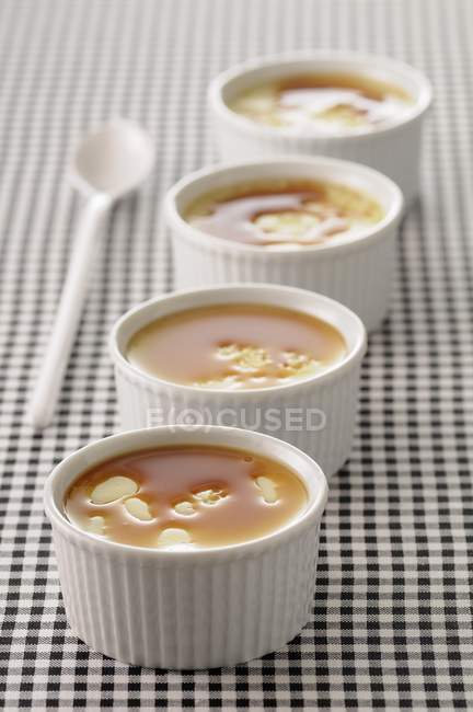 Closeup view of Creme caramels in bowls with spoon — Stock Photo