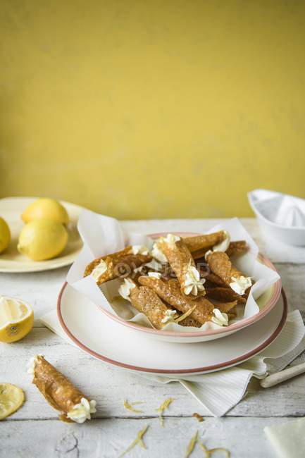 Closeup view of Brandy snap Tuilles with lemon cream in a bowl — Stock Photo