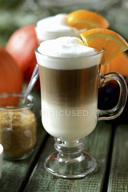 Latte em copo de vidro com fatia de laranja — Fotografia de Stock