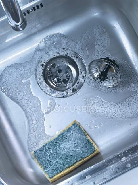 Top view of sponge and filter in metal sink — Stock Photo
