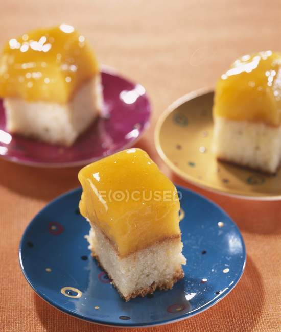 Peach cake squares on plates — Stock Photo
