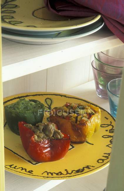 Фаршировані перці в прованському стилі на жовтій тарілці над столом — стокове фото