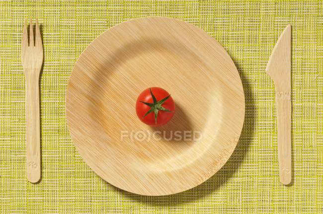 Wooden plate and tomato — Stock Photo