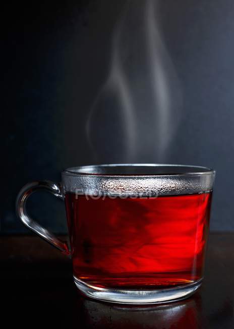 Chá de frutas de baga vermelha quente em caneca de vidro — Fotografia de Stock