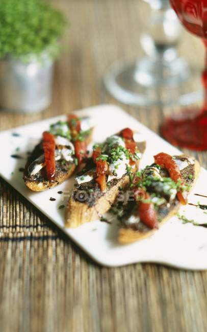 Tapenade sauce and anchovies on toasts — Stock Photo