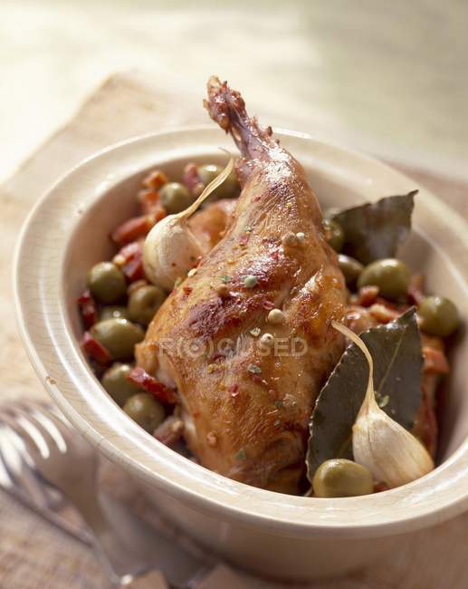 Closeup view of rabbit with olives, garlic and bay leaves — Stock Photo