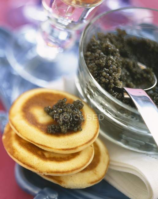 Vista de primer plano de caviar en Blinis apilados - foto de stock
