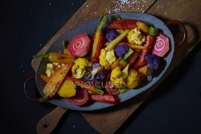 Légumes frits sur plaque bleue sur bureau en bois — Photo de stock