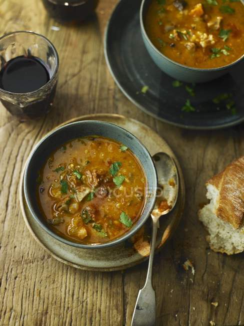 Возвышенный вид на каштановый суп Чоризо с хлебом и напитками — стоковое фото