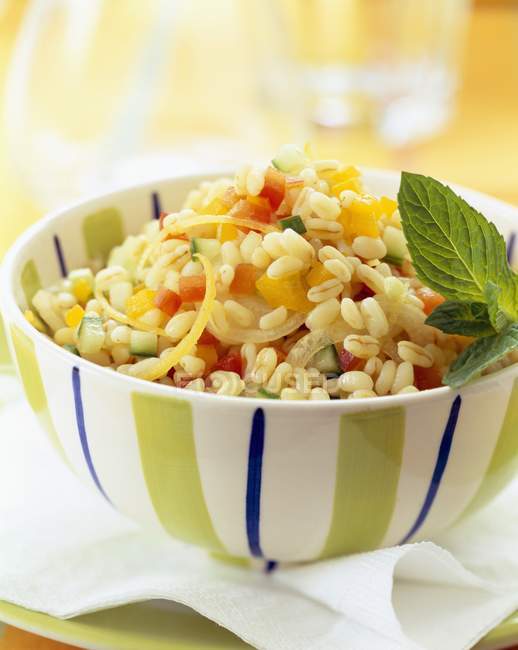 Wheat tabouleh with lemon and mint in bowl over paper napkin — Stock Photo
