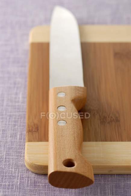 Vista de cerca del cuchillo de cocina en la tabla de cortar - foto de stock