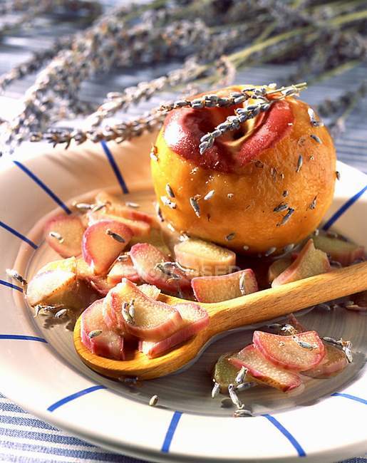 Ребгар і персик з лавандою на тарілці з дерев'яною ложкою — стокове фото
