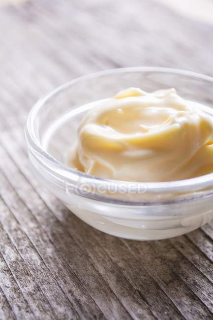 Mayonnaise in a glass bowl on wooden surface — Stock Photo