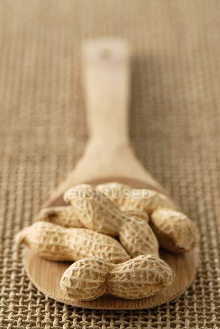 Wooden spoonful of peanuts — Stock Photo