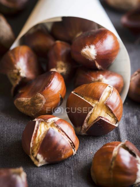 Roasted chestnuts in paper cone — Stock Photo