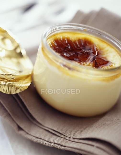Closeup view of Creme brulee in a small glass jar on cloth — Stock Photo