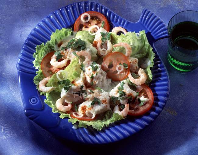Салат из креветок и морского леща на тарелке — стоковое фото