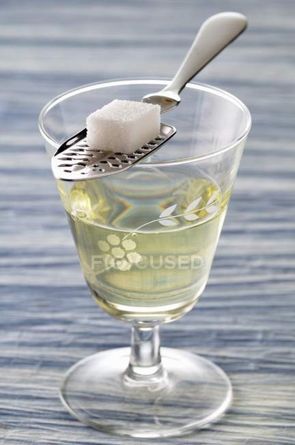 Closeup view of Absinthe glass with spoon and sugar lump — Stock Photo