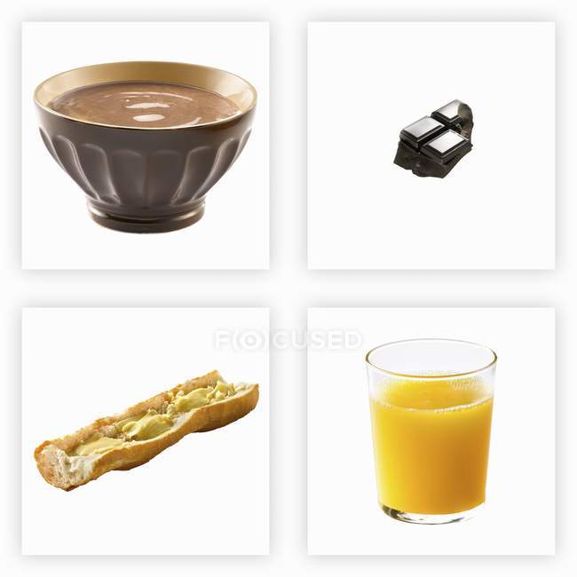 El desayuno infantil en las plazas - la escudilla, el jugo en el vaso, el pan y el chocolate - foto de stock