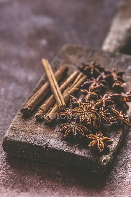 Vista close-up de anis estrela e paus de canela em uma placa de madeira — Fotografia de Stock